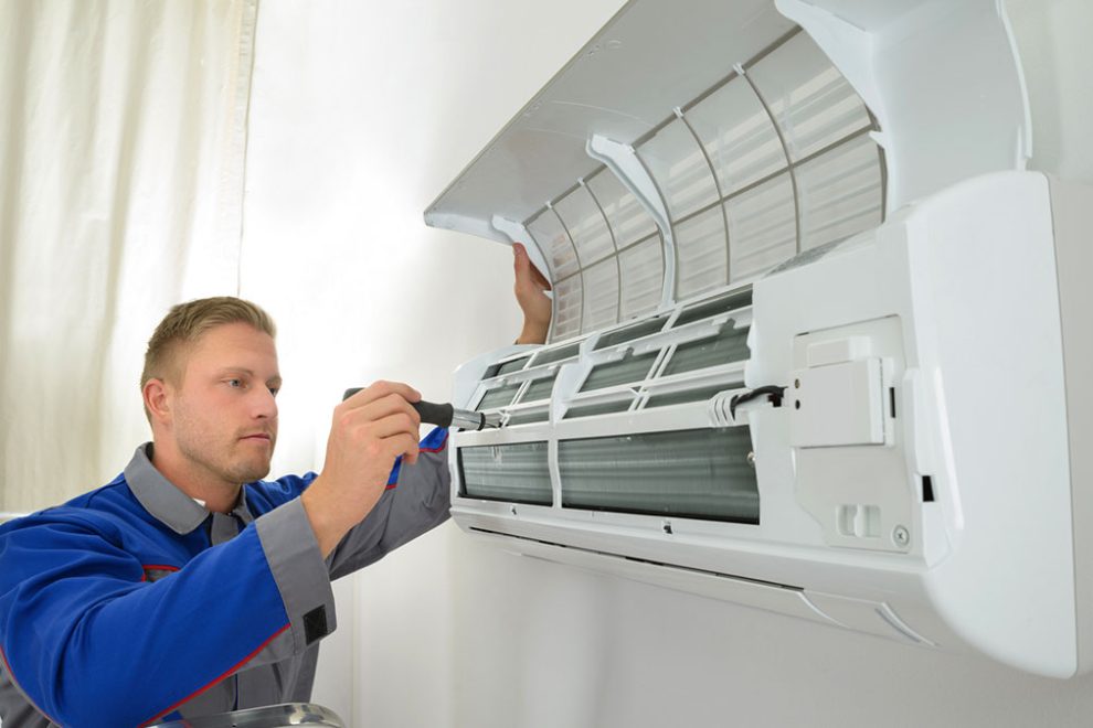 AES Air Conditioning Engineer Servicing a wall-mounted internal AC unit